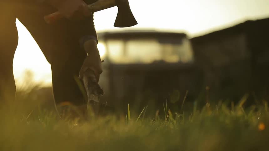 Man cutting some wood with a small hand axe