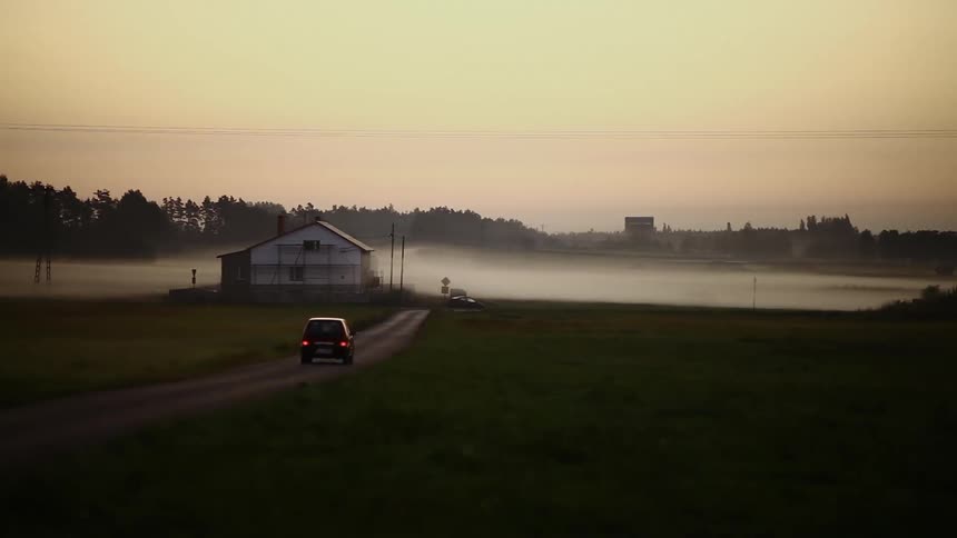 A car drives towards the fog
