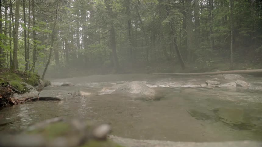 Mist hangs in the air above a fast flowing stream