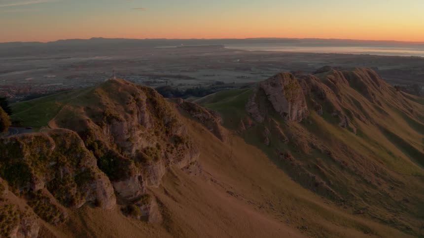 Dusk is falling beyond a canyon in a desert landscape