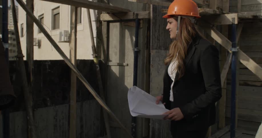 A man and woman inspect a construction site during the day