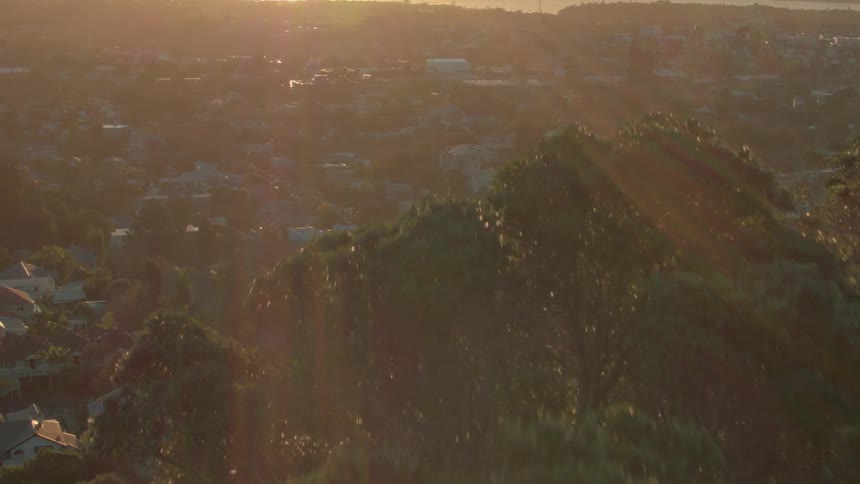 The sun is casting rays on a coastal community at dusk