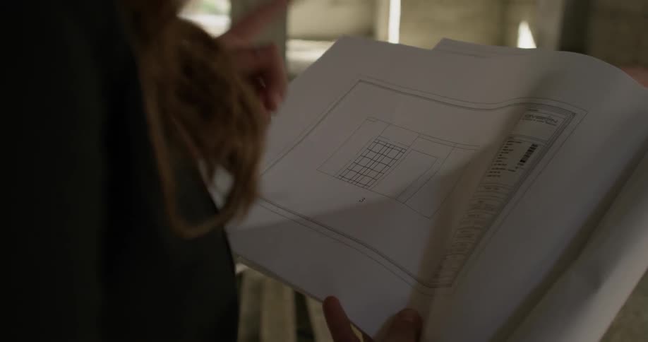 A woman points and discusses building plans at a construction site