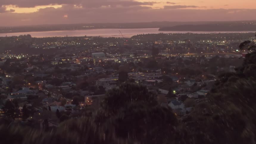 Lights gleam in houses and on streets in a community at dusk