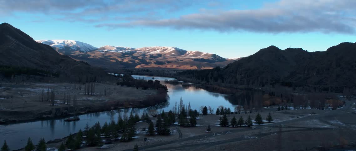 A river reflects the sky and surrounding landscape