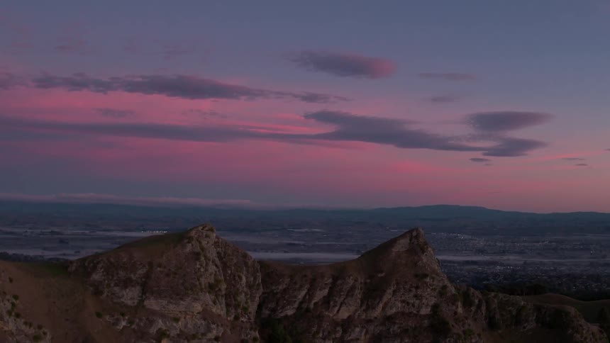 Mountains sit under a cloudy sky at dawn