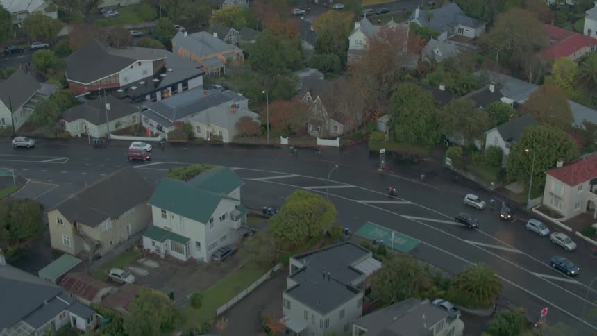 Vehicles pass by on a neighborhood street