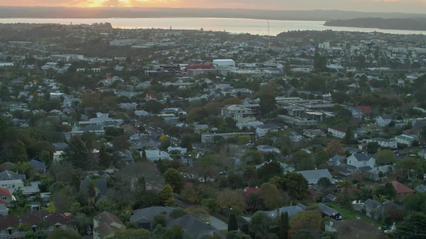 The sun is setting beyond a community on the coast