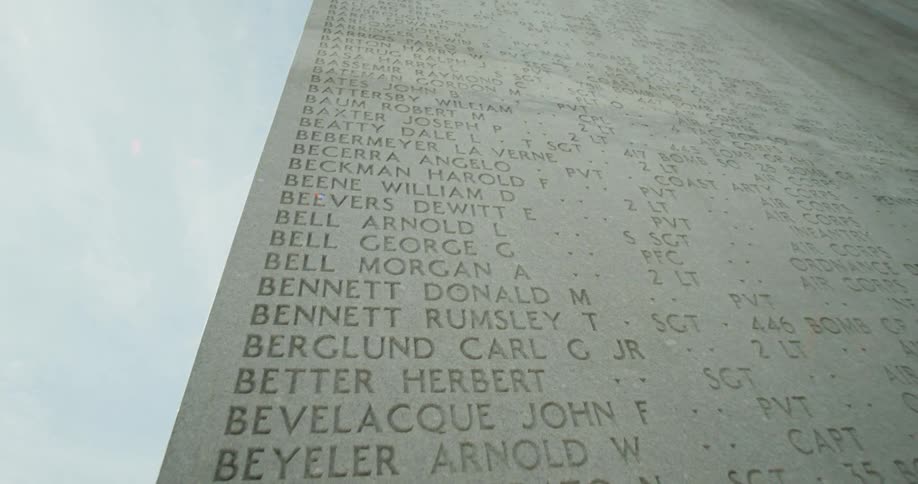 A tall concrete monument engraved with names
