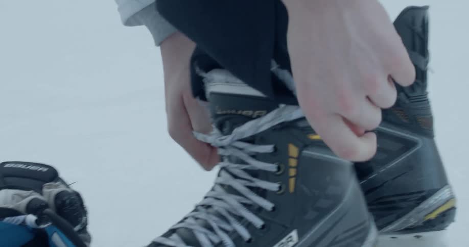 Hockey player ties their ice skates