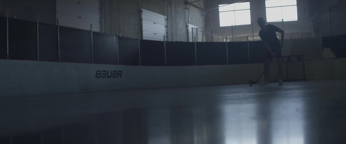A hockey player is practicing his puck handling skills
