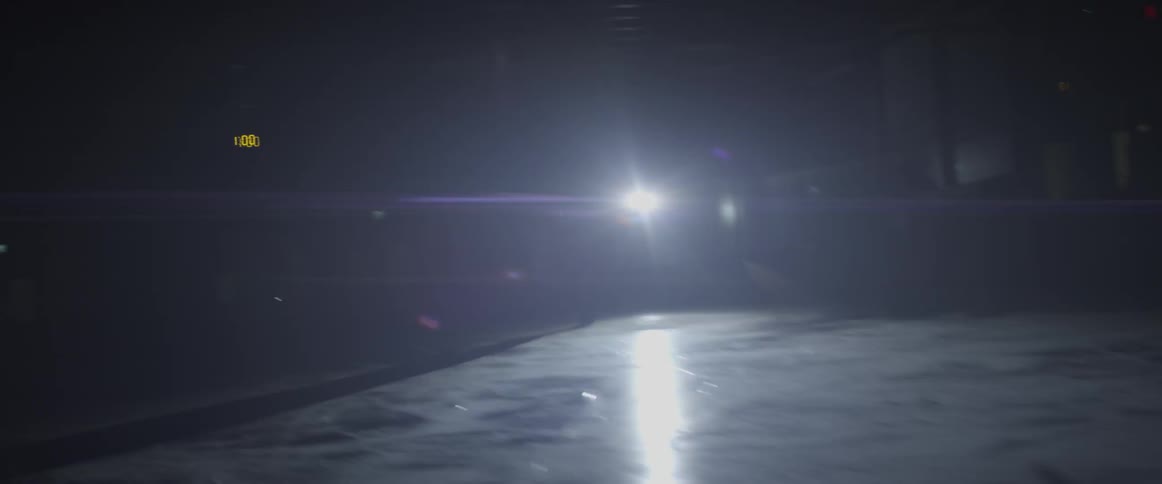 An ice hockey player skates in an empty rink at night