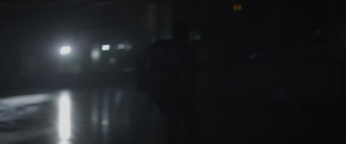 A hockey player skates on the ice in the dark