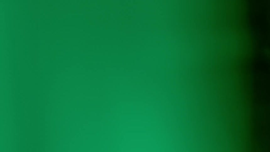 Green colored smoke waves in the light