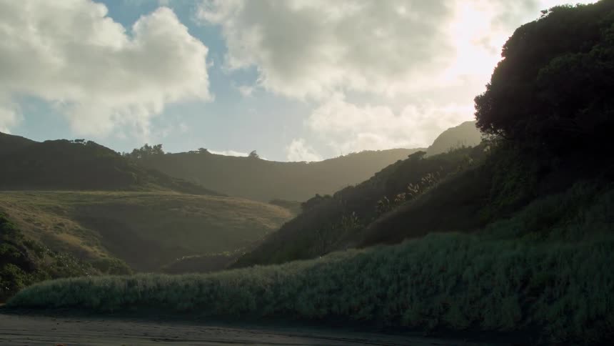Rolling hills sit under the bright sun