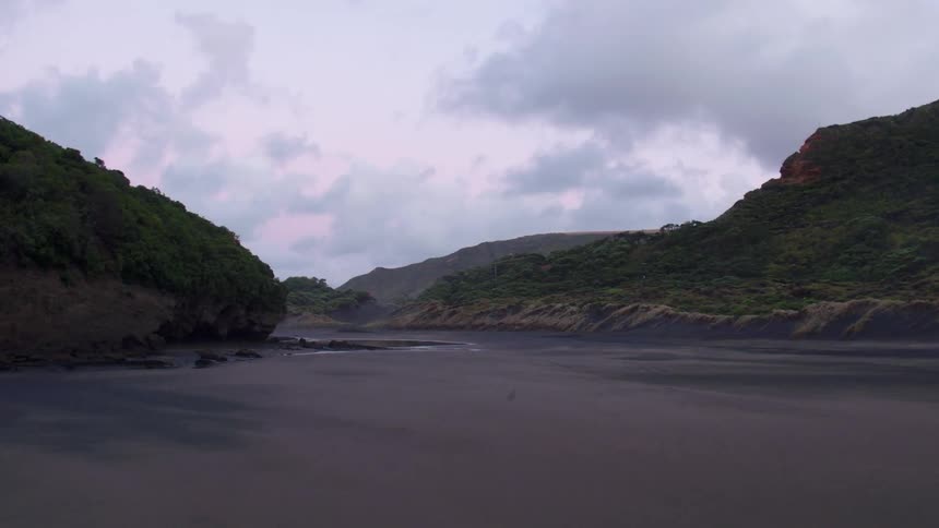 Clouds hang over a beach at dusk