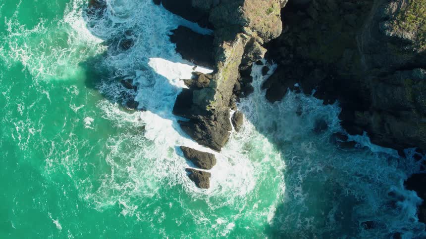 Water crashes on a narrow bit of rock