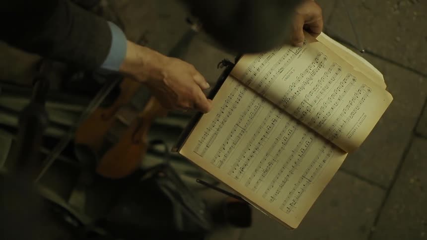 A man turns a page in a music book