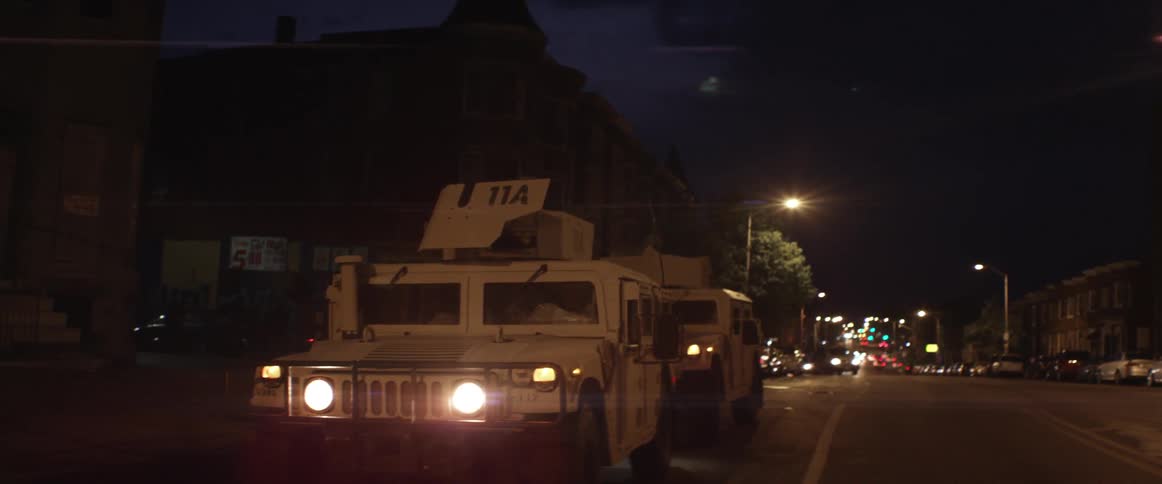 Armored jeeps in city street at night