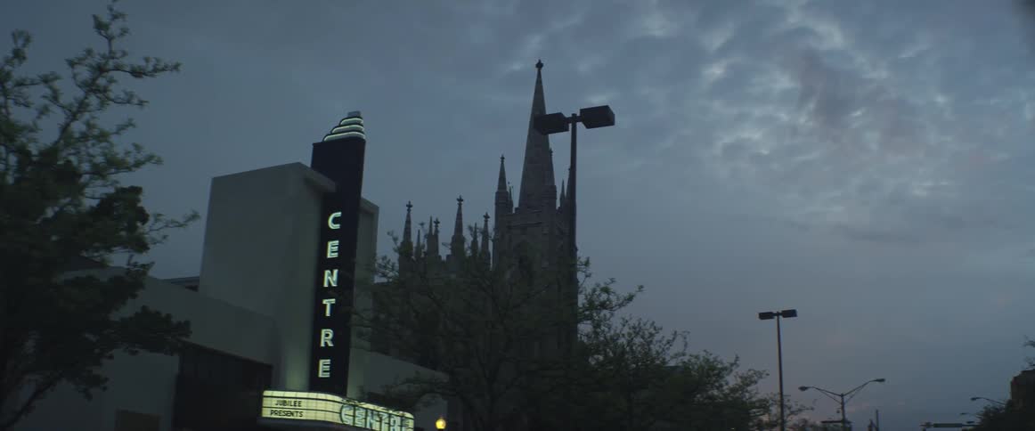 Driving past a movie theater on a cloudy day