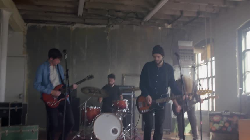 A band is playing music inside during the day