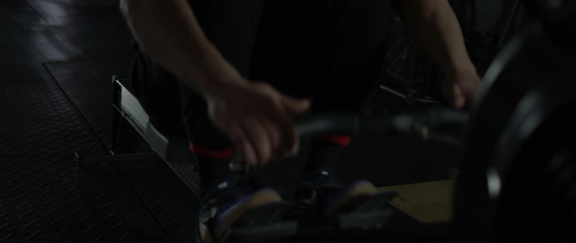 A man exercises in a gym with a rowing machine