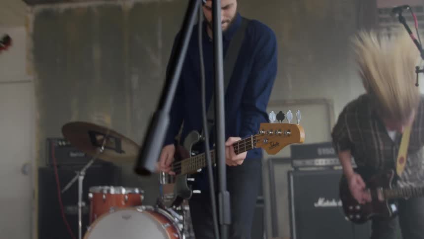 A rock band is playing in a building during the day