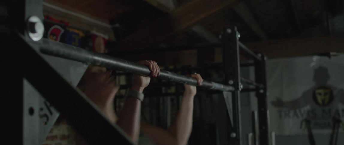 Woman does chin ups on a bar