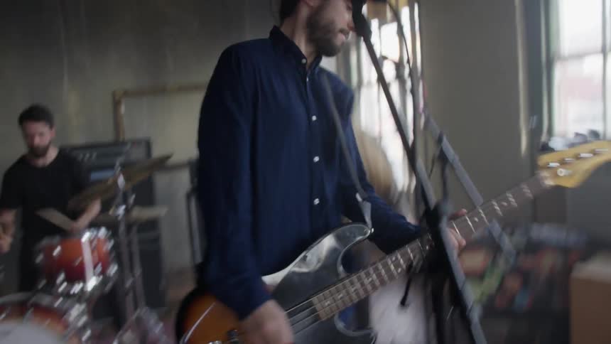 A band comprised of young men is playing music during the day