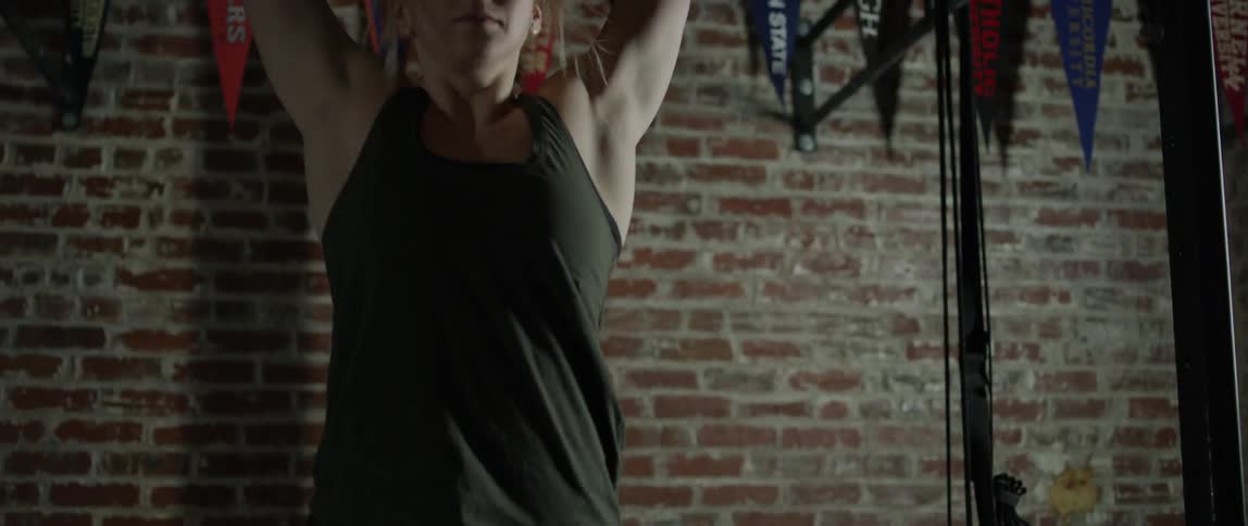 Woman does chin ups on a bar