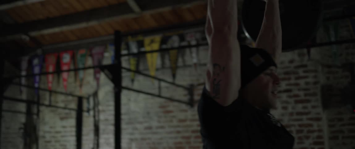 A man is deadlifting weights in a gym during the day