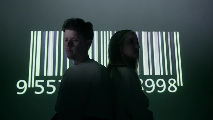 A couple stand in front of a flashing barcode