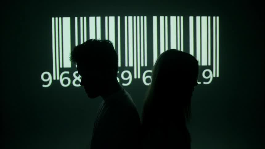 A barcode flashes on the wall behind a young man and woman