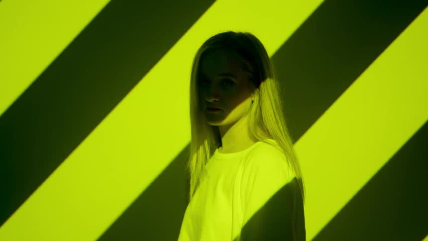 A woman is staring straight ahead as she stripes are project over her