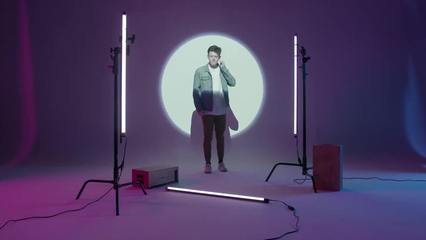 A man stands in front of a bright projection