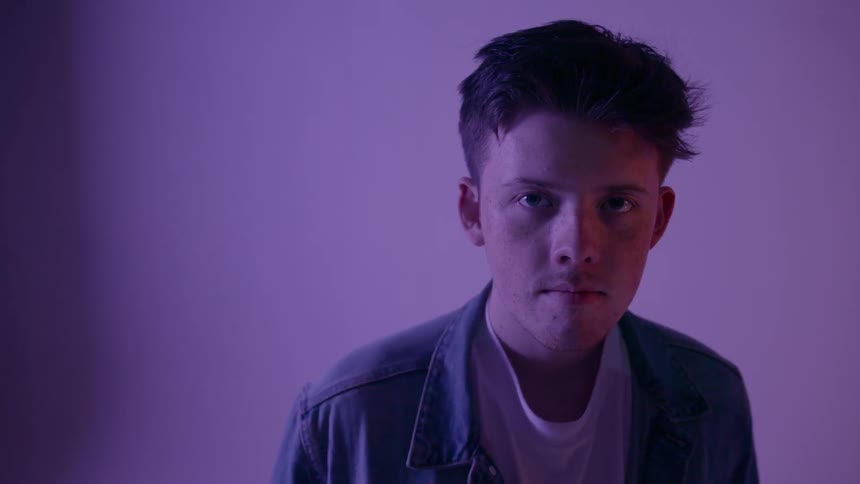 A man stares out in a purple room