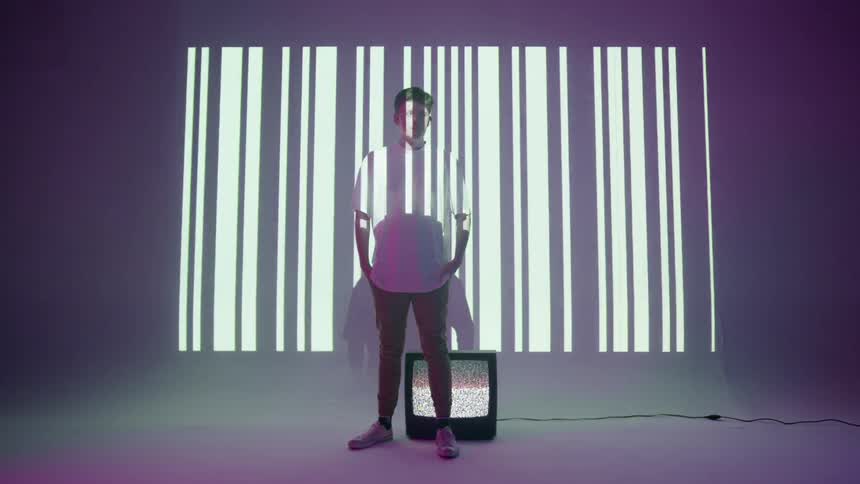 A man stands in front of a barcode projection