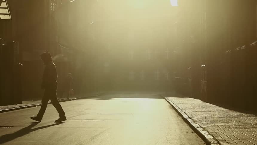 A man is walking down the street in the morning
