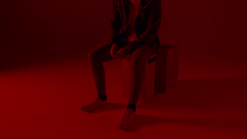 A man sits in a red room