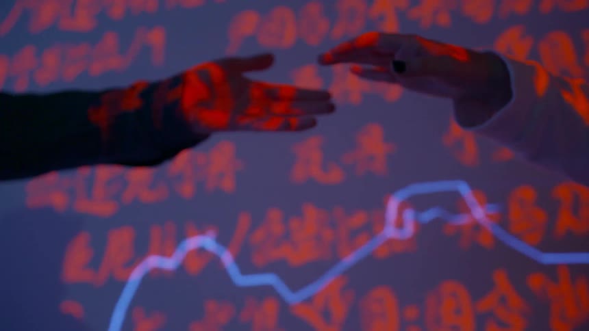 A man and woman reach out to clasp hand while a screen project images behind them