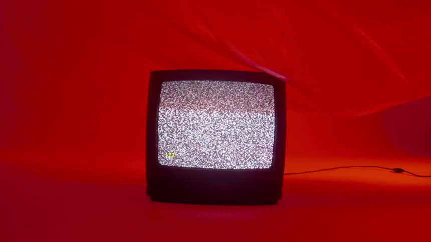 Opaque sheeting blows and billows over a television in a red room