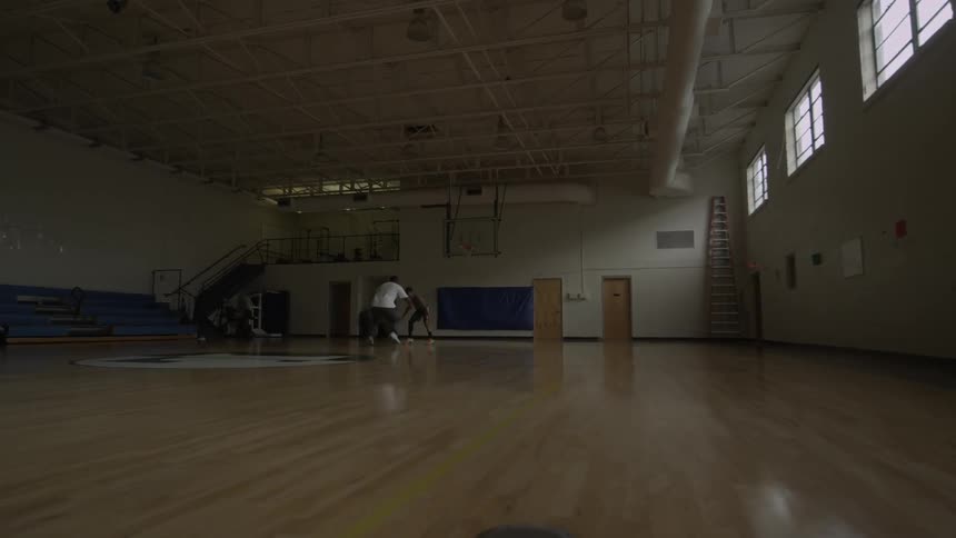 Men play basketball on an indoor court