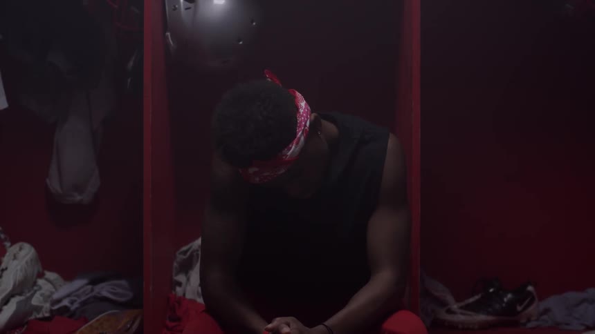 An athlete is sitting rotating his neck in the locker room