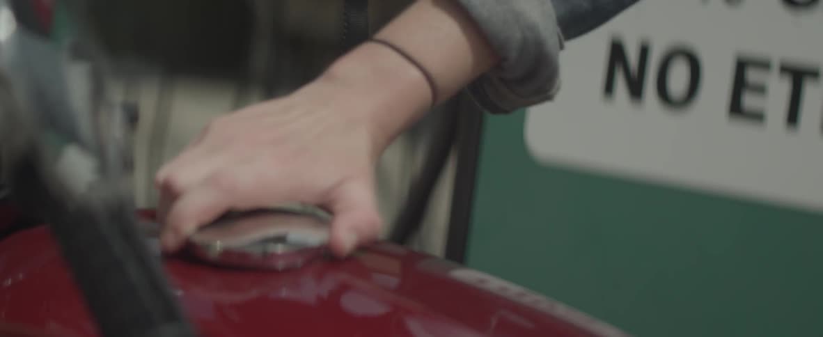 A person places a helmet on a motorcycle
