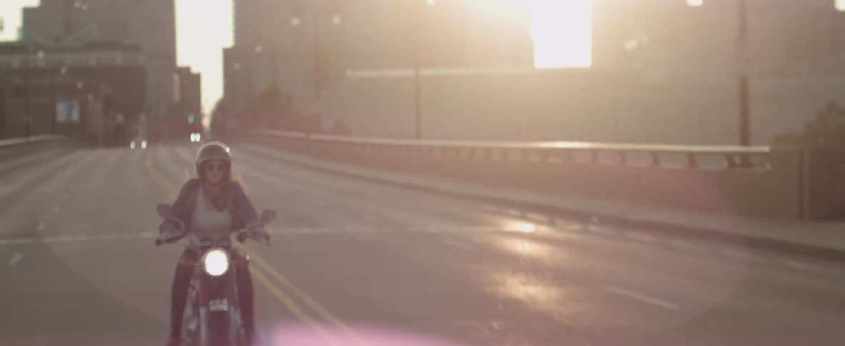 Woman rides motorcycle down a highway