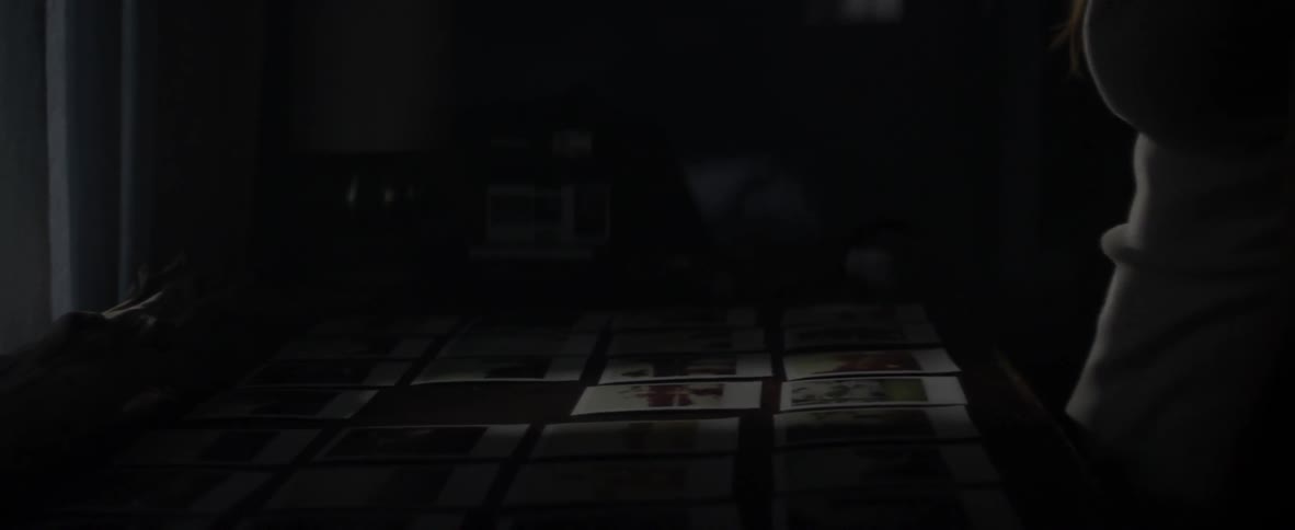 A person arranges photographs on a table