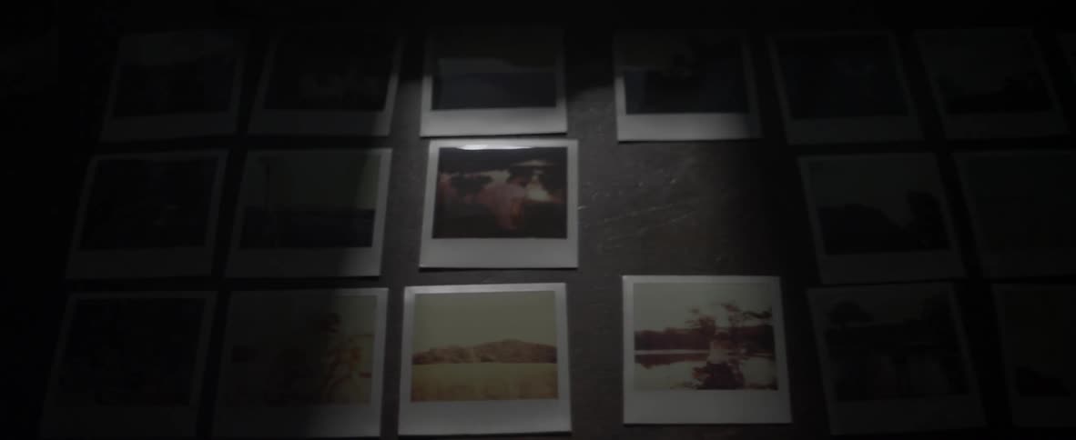 Someone looks at photographs on a wall