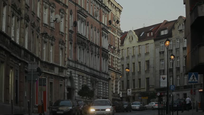 Vehicles move on the city roads while the pedestrians move along the sidewalk