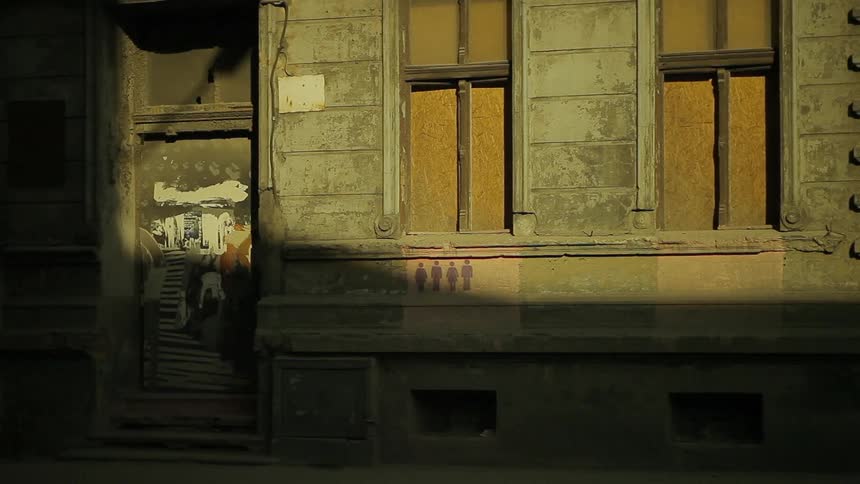 An rundown urban building in shadows and sunlight at street level