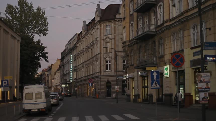 One person walking down a city street at sunset